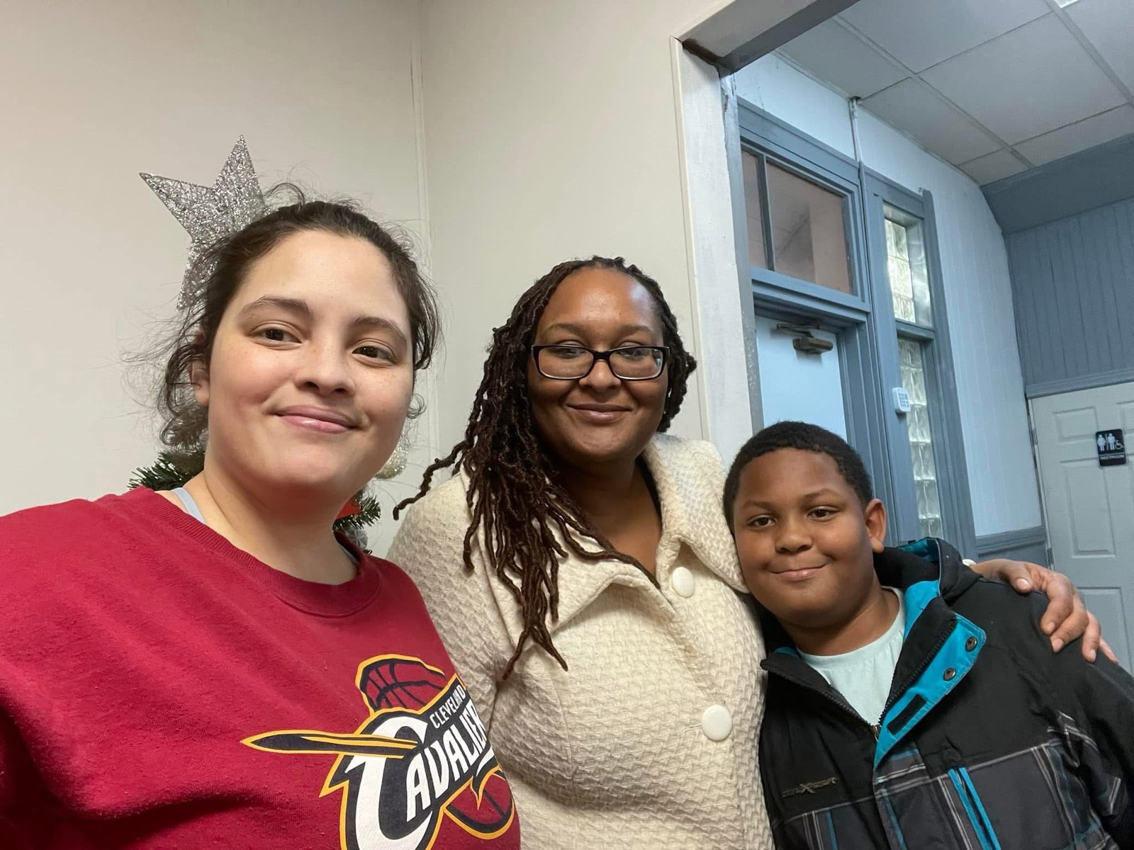 Three community members sharing a smile at a gathering