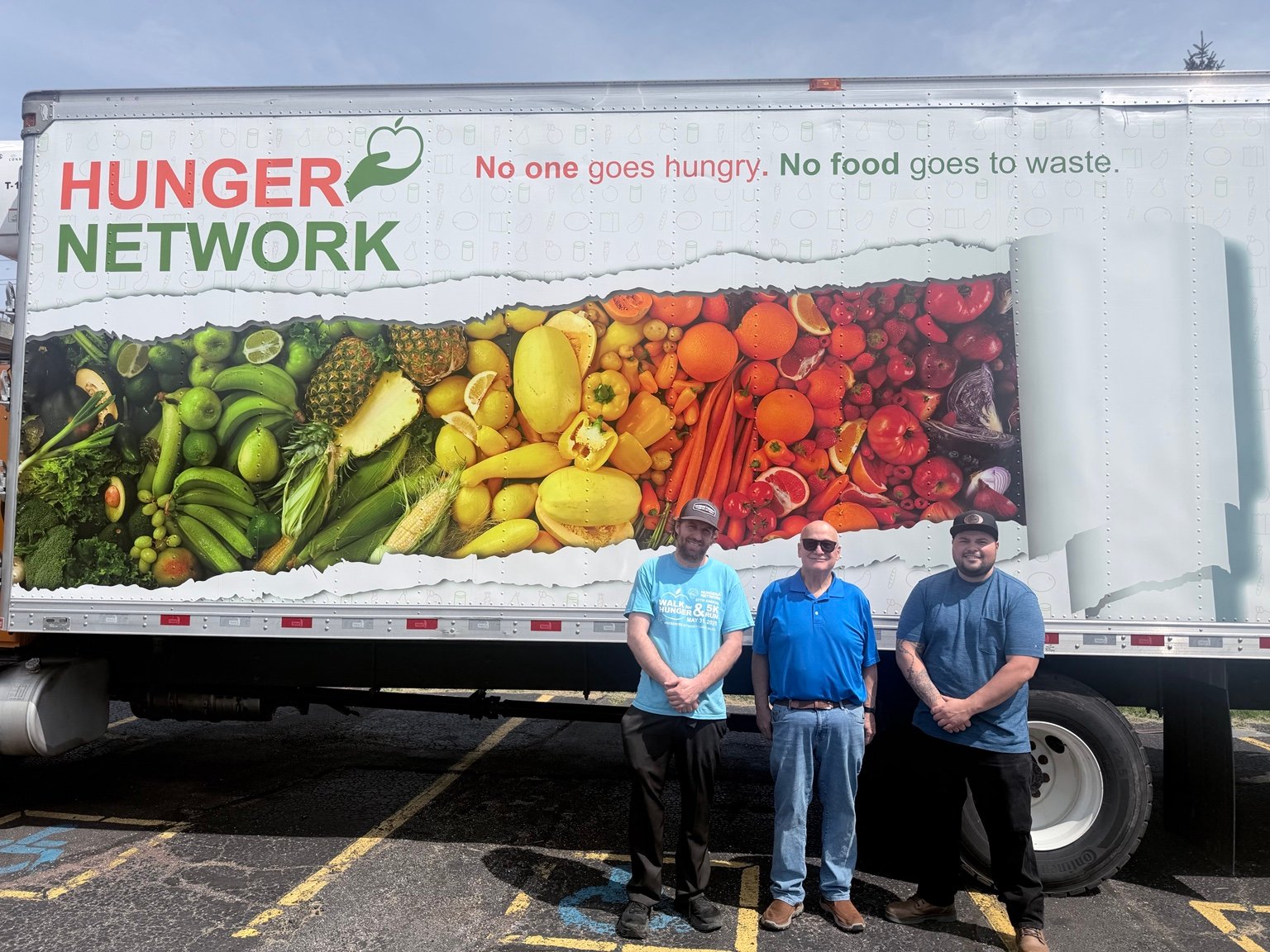 Community members standing beside the Hunger Network truck