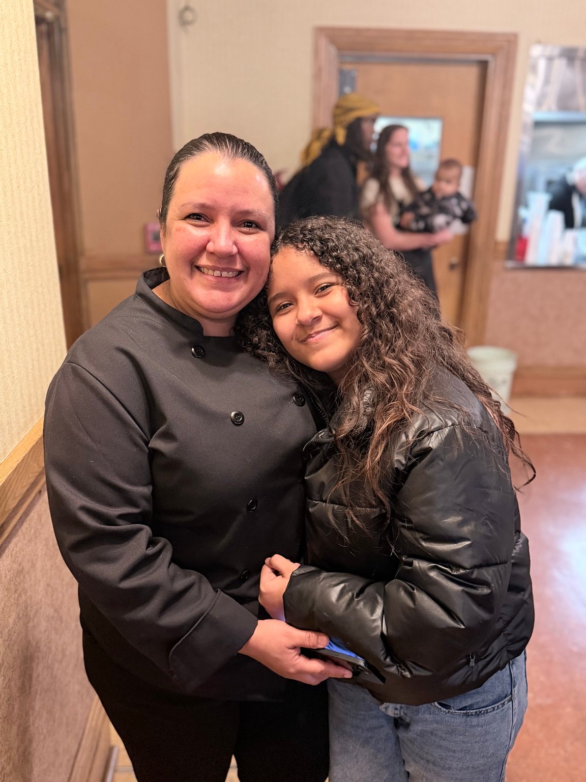 Two community members sharing an embrace